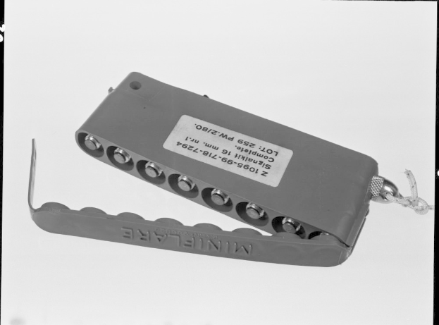 Schwarzes und weißes Foto eines metallenen Elektroschockers mit einer Kette, auf dem Text und Zahlen auf beiden Seiten zu sehen sind.