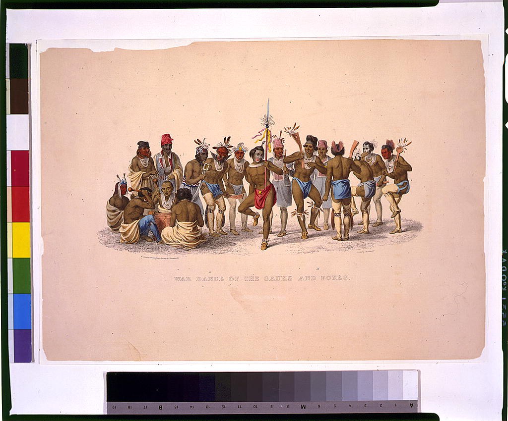 Gruppe von Männern in traditioneller indianischer Kleidung führt Kriegstanz auf buntem Papier mit Text aus.