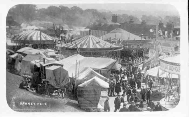 Schwarz-weißes Karnevalsszenario mit Zelten, Menschen, Karren, Pfählen, Bäumen und Gebäuden, beschriftet mit "Barnet Fair, London, England" unten.