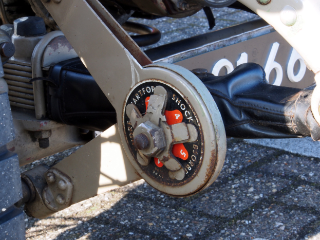 Ein Nahaufnahme eines Motorrads mit einem schwarzen Lenker und einem silbernen Bremssattel, das auf einer Straße positioniert ist.