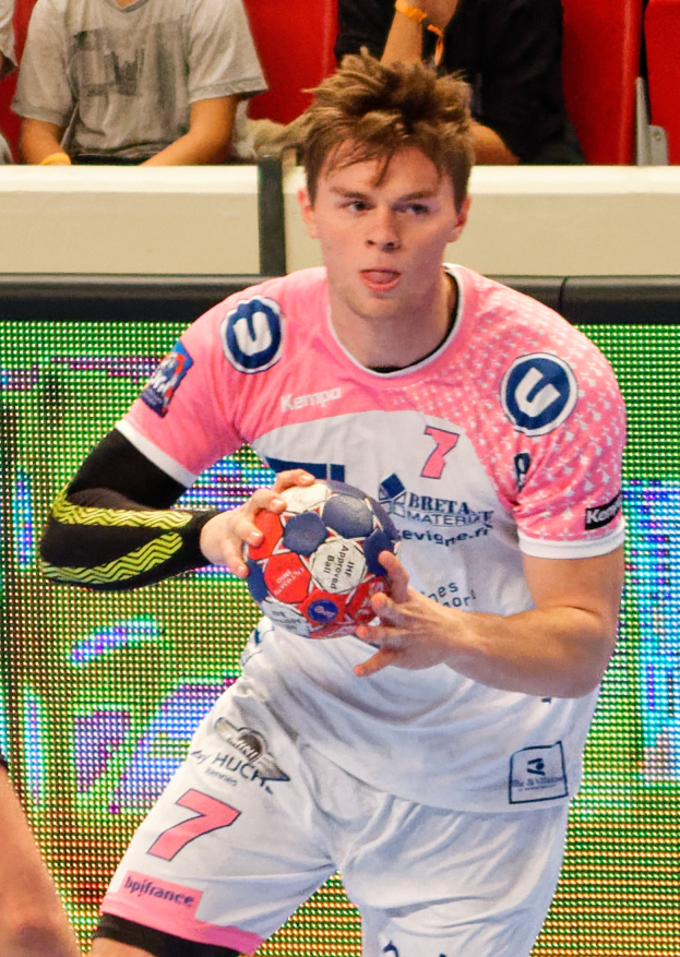 Männer bei einem Handballspiel auf einem Court während des Futsal-Weltmeisterschaft 2019 zwischen Bayern München und Paris Saint-Germain, mit Zuschauern im Hintergrund.