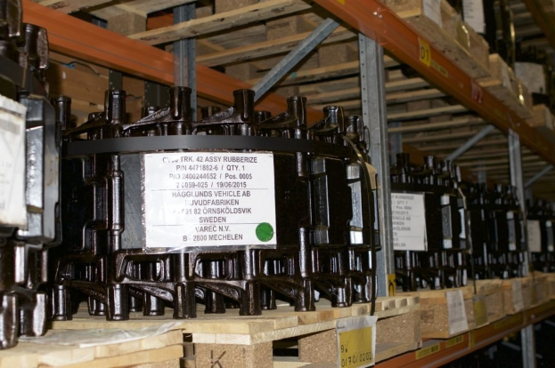 Ein Lagerhaus voller Metallverteilgehäuse auf Holzpaletten, jedes mit einem Aufkleber versehen, der verschiedene Komponenten anzeigt.