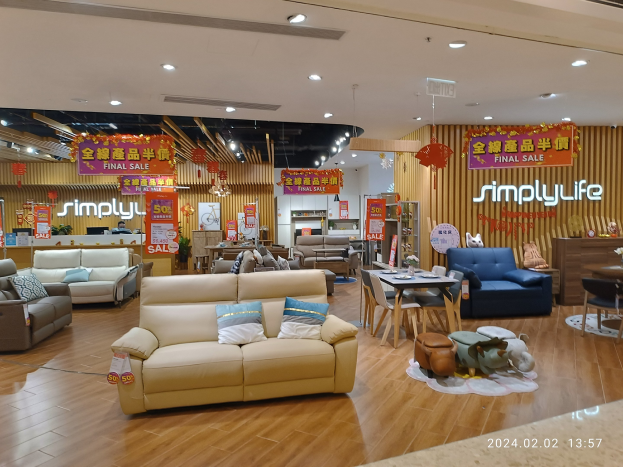 Ein Möbelgeschäfts-Innenraum mit Sofas, Tischen, Stühlen, Hockern und anderen Gegenständen sowie Deckenlampen und Texttafeln, einschließlich eines Wasserzeichens.