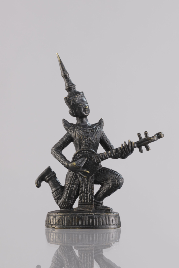 Bronzestatue eines Gitarrespielers vor einem weißen Hintergrund.