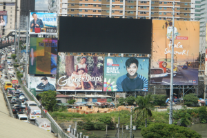 Ein aufgeschlagenes Buch mit einer Illustration einer Stadtansicht mit Gebäuden, Bäumen und Menschen, begleitet von beschreibendem Text.